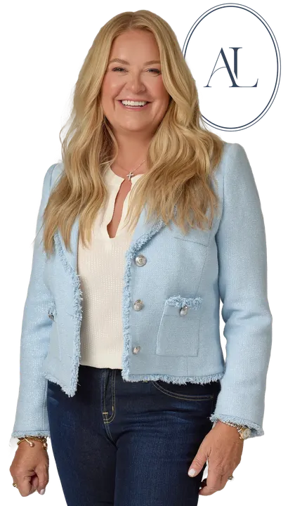 Amy Lacey in a light blue jacket with her AL monogram