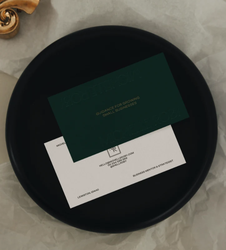 Green and cream Michelle Roby business cards displayed on a black tray